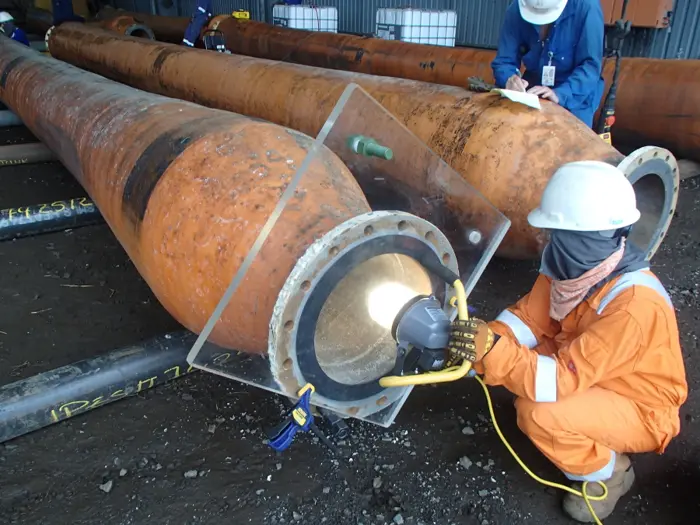 Specialist inspecting a marine hose end fitting